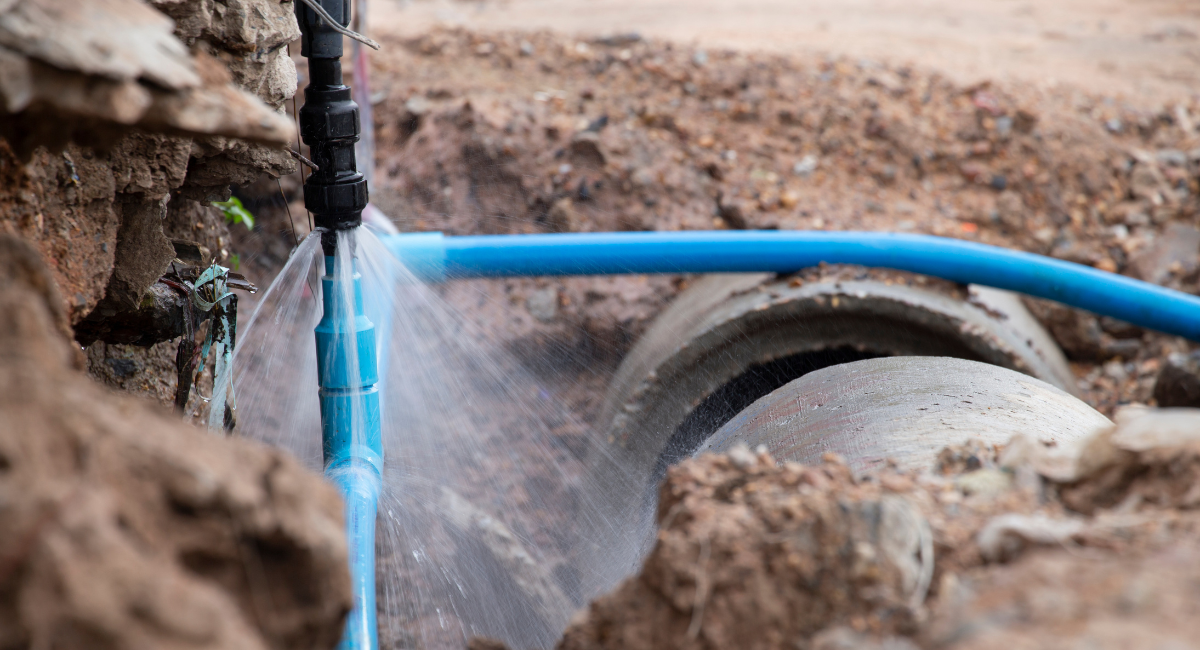 Emergency plumbers in Clanton repairing a burst water pipe with high-pressure leakage.