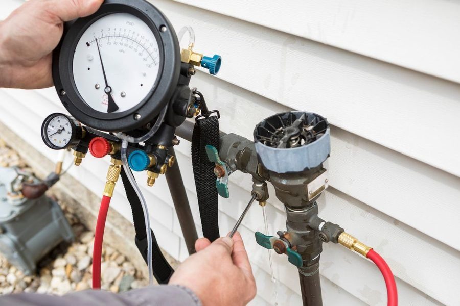 Plumber writing on a clipboard sewage ejector pump replacement.